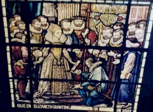Queen Elizabeth grants the fabric of St. John's church to the parishioners of Chester in 1581, as depicted in the stain glass window above the main entrance.